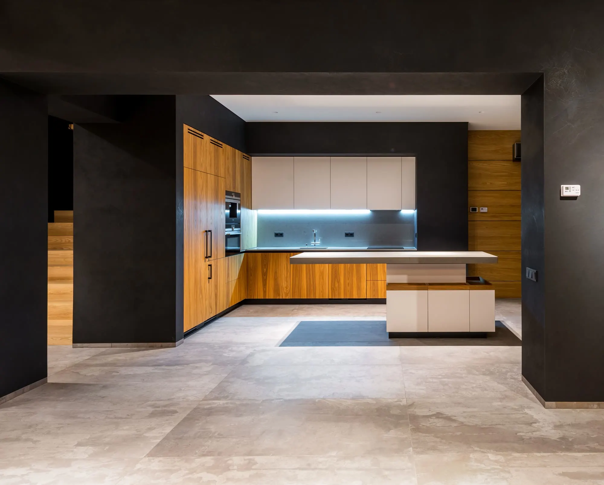 Cocina abierta al salón con isla y suelo de gres, en una vivienda reformada