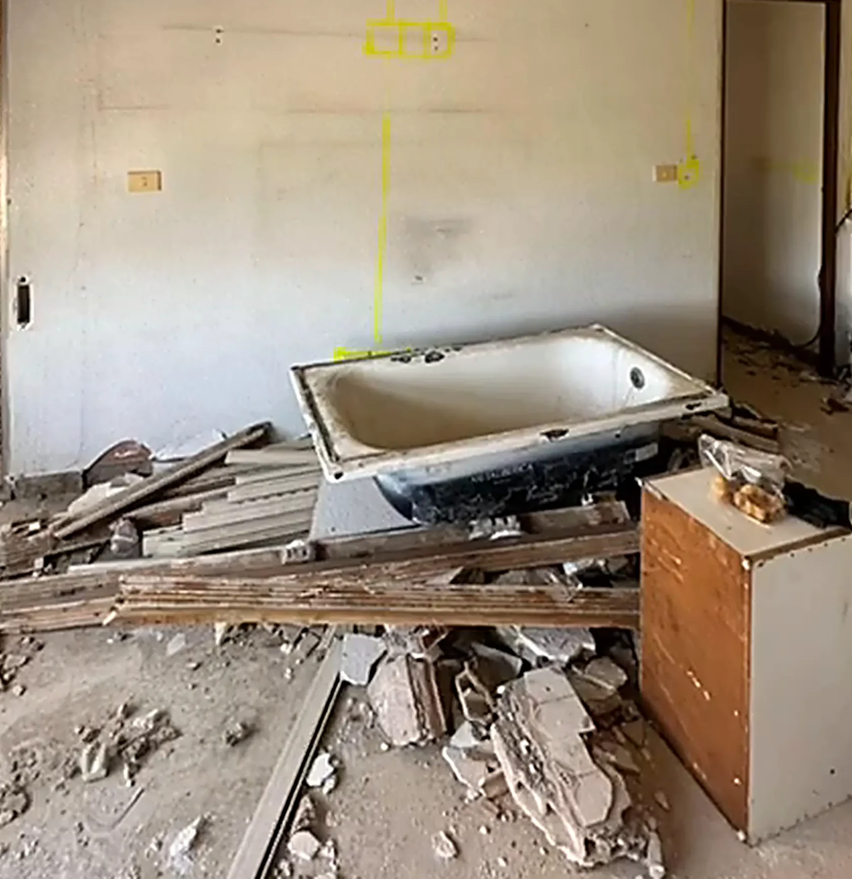 Baño en demolición: la bañera arrancada sobre los escombros del alicatado