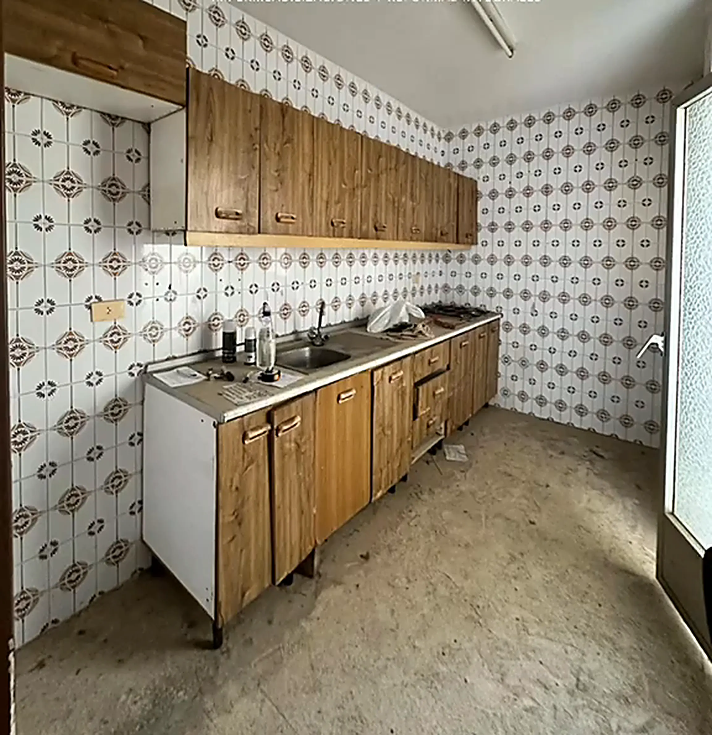 Cocina antigua con muebles de madera y azulejo estampado
